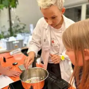 frau und mädchen vorm kochtop, um kosmetik herzustellen